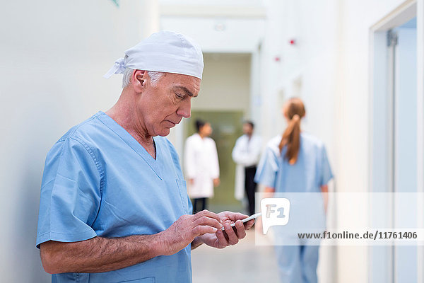 Arzt im Krankenhaus schaut auf Handy