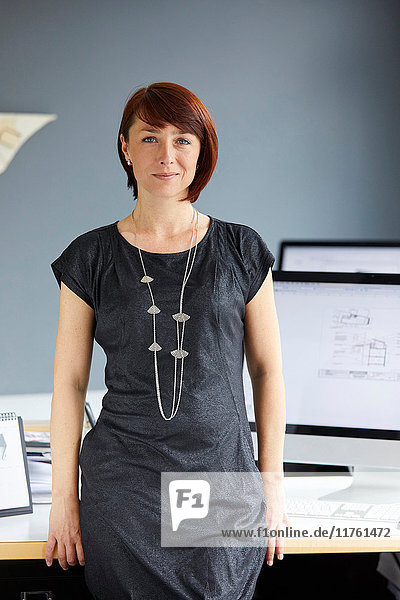 Porträt einer selbstbewussten Designerin am Büroschreibtisch