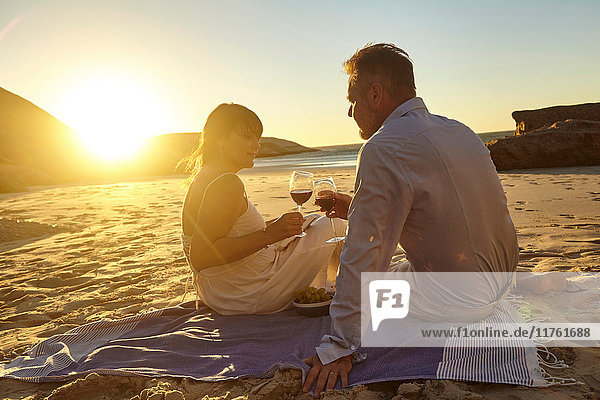 Ehepaar trinkt Rotwein am Strand