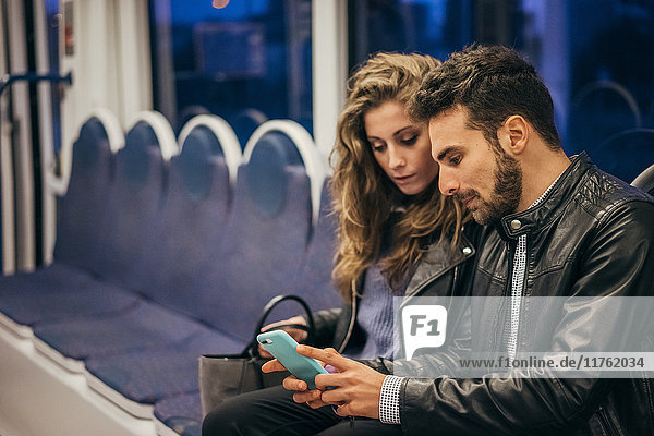 Couple using mobile phone in train  Florence  Italy