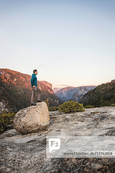 Man looking out from top of boulder Yosemite National Park California USA