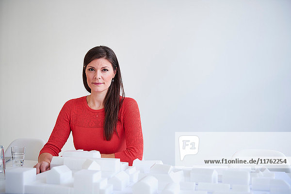 Portrait of architect with architectural model looking at camera