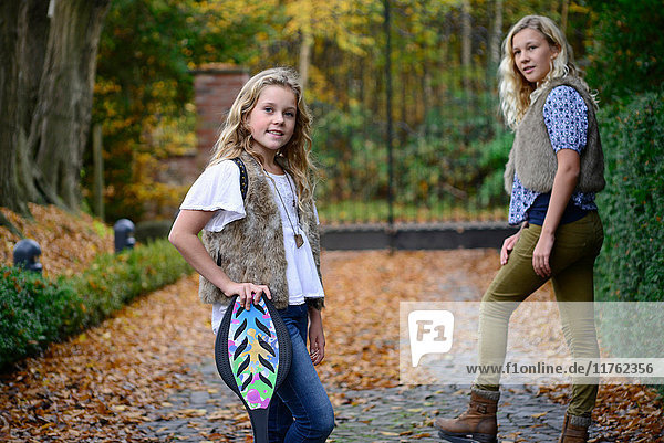 Porträt von zwei Schwestern mit langen blonden Haaren im Herbstpark