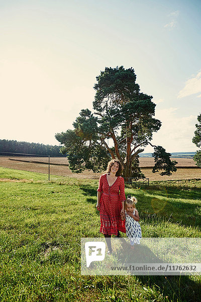 Porträt einer schwangeren Frau und einer Kleinkind-Tochter in Feldlandschaft