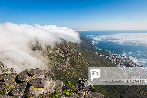 Der Tafelberg ist von einem orographischen Wolkentuch bedeckt  darunter die Camps Bay in einer niedrigen Wolke  Kapstadt  Südafrika  Afrika