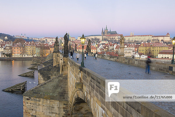 People on the historical Charles Bridge on Vltava River at dawn  UNESCO World Heritage Site  Prague  Czech Republic  Europe