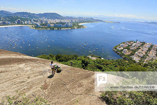 Abseiler in Morro da Urca in Rio de Janeiro mit Panoramablick im Hintergrund  Rio de Janeiro  Brasilien  Südamerika