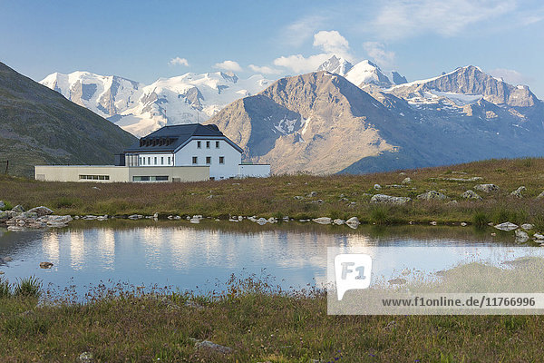 Der Alpensee umrahmt das von Gipfeln umgebene Hotel  Muottas Muragl  Samedan  Kanton Graubünden  Engadin  Schweiz  Europa