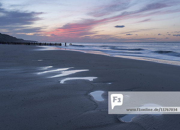 Schöne Sonnenuntergangsfarben über dem Strand bei Ebbe in Mundesley  Norfolk  England  Vereinigtes Königreich  Europa