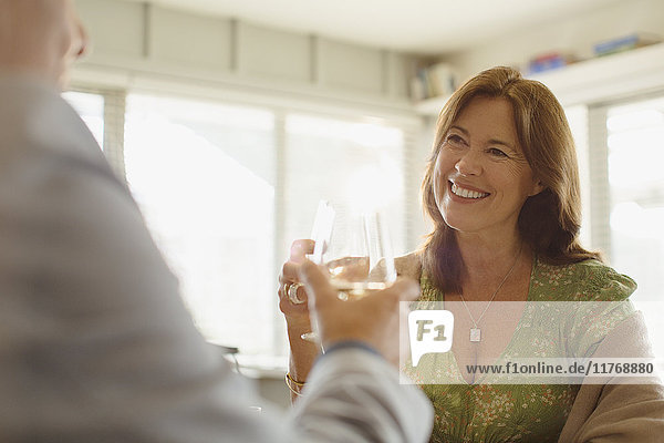 Smiling couple toasting wine glasses at restaurant