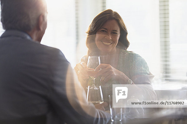 Smiling mature couple drinking wine  dining at restaurant table