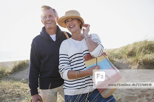 Smiling mature couple on sunny beach