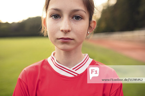 Portrait of confident female soccer player standing on field