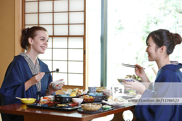 Weiße Frau in Yukata beim Essen mit japanischem Freund in einem traditionellen Ryokan  Tokio  Japan