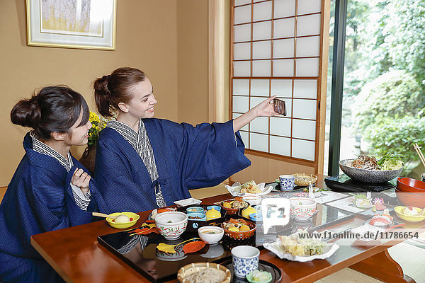 Weiße Frau in Yukata isst mit japanischem Freund in einem traditionellen Ryokan  Tokio  Japan