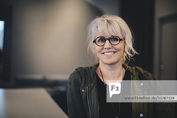 Porträt einer glücklichen Geschäftsfrau mit Brille im Büro
