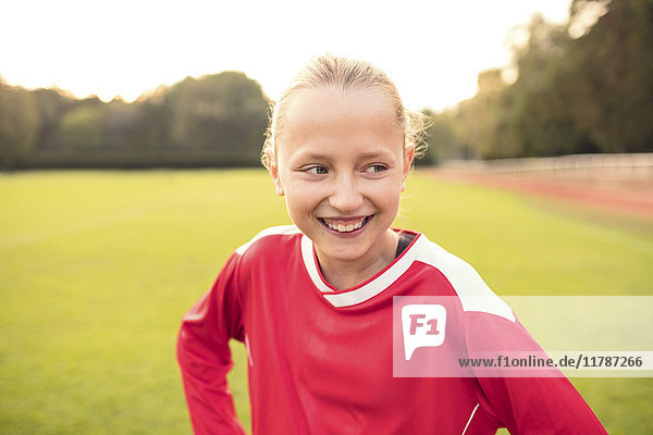 Happy soccer player looking away while standing on field