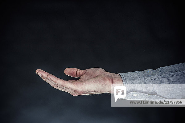 Ausgestreckte Hand eines Mannes  Handfläche nach oben gerichtet