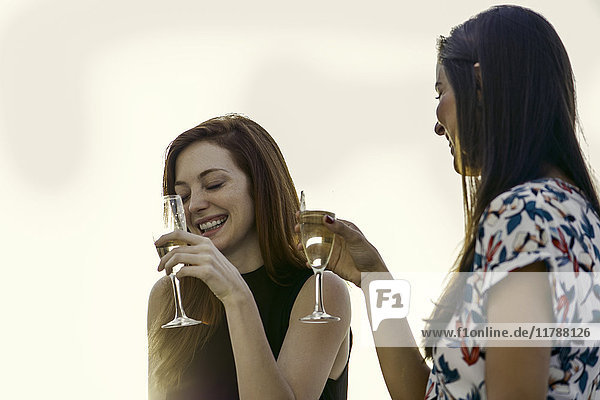 Frau trinkt gemeinsam Champagner im Freien