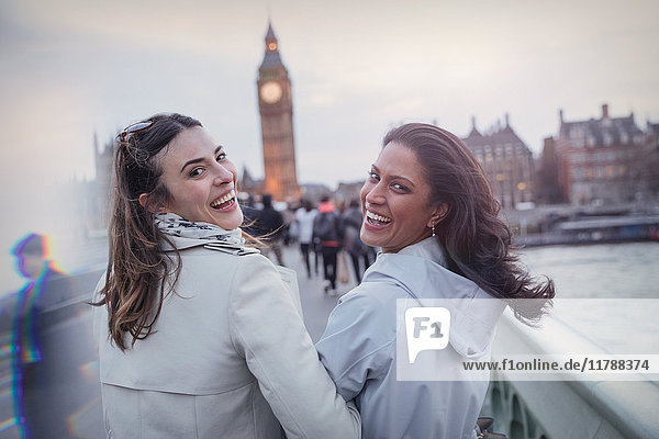 Portrait lächelnde  enthusiastische Frauen  die auf der Brücke in Richtung Big Ben  London  UK  gehen.