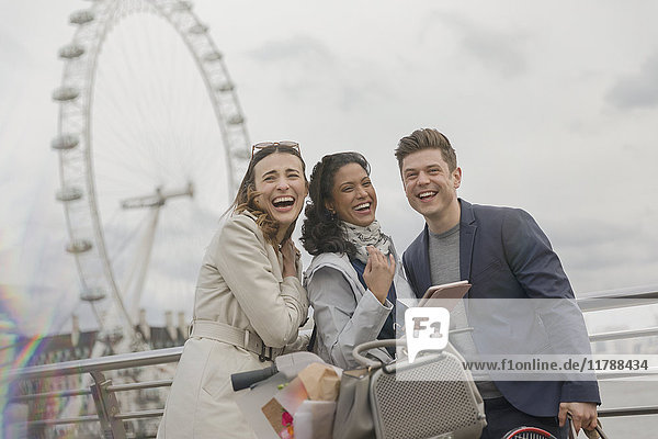 Portrait lachende Freunde mit digitalem Tablett bei Millennium Wheel  London  UK