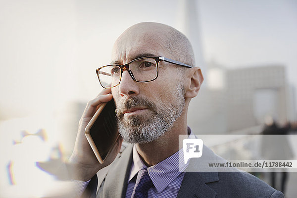 Close up serious businessman talking on cell phone