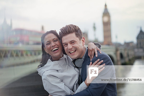 Portrait enthusiastic  laughing couple tourists standing at Westminster Bridge  London  UK
