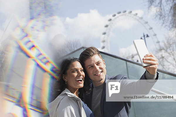 Smiling couple tourists taking selfie near Millennium Wheel  London  UK