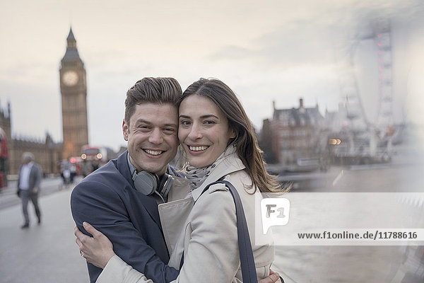 Portrait smiling couple tourists hugging in front of Big Ben  London  UK
