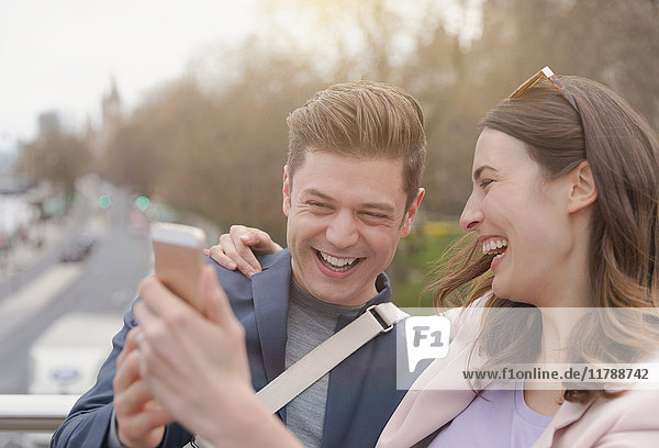 Laughing couple taking selfie with camera phone