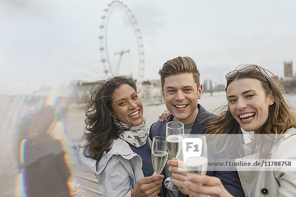 Portrait begeisterte  lächelnde Freunde beim Feiern  Trinken von Champagner am Millennium Wheel  London  UK