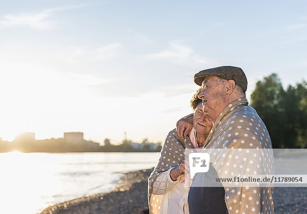 Seniorenpaar entspannt am Strand bei Sonnenuntergang
