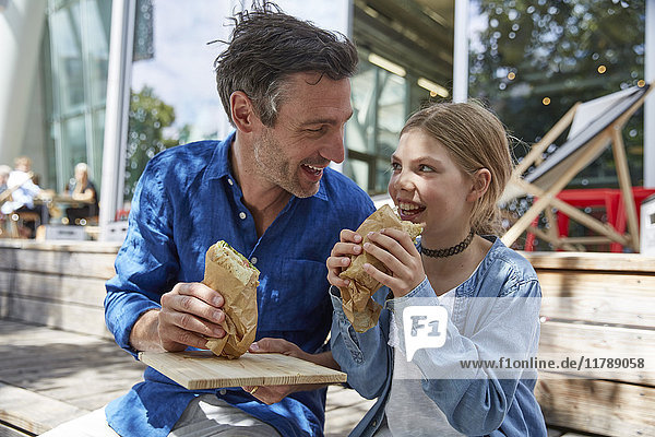 Vater und Tochter bei einem Snack in einem Outdoor-Café