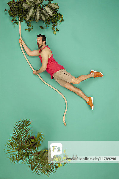 Man swinging on a liana through the jungle
