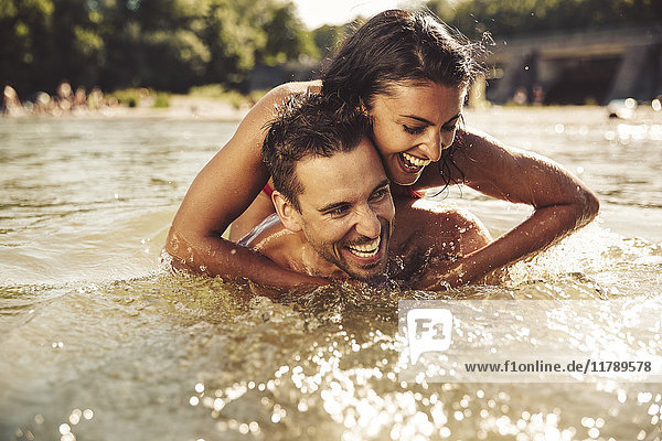 Lachendes Paar beim gemeinsamen Baden im Fluss