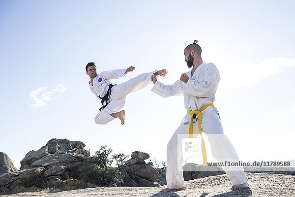 Man doing a jump kick during a martial arts combat