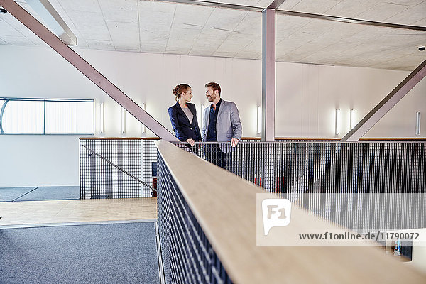 Businessman and businesswoman standing on office floor