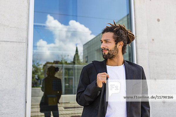 Porträt eines jungen Geschäftsmannes mit Dreadlocks vor dem Gebäude