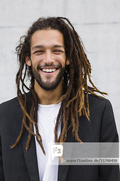 Porträt eines lächelnden jungen Geschäftsmannes mit Dreadlocks