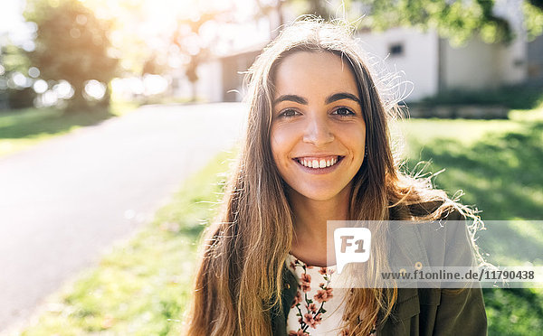 Porträt einer lächelnden jungen Frau im Freien