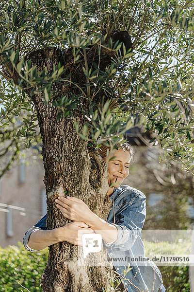 Woman in garden hugging a tree