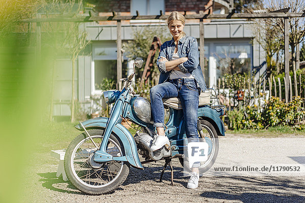 Smiling woman with vintage motorcycle