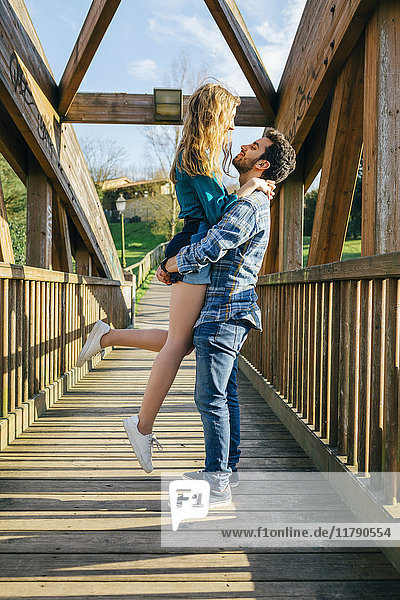 Junges verliebtes Paar auf Holzbrücke