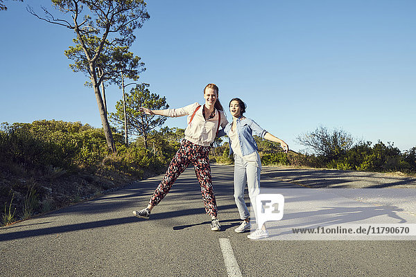 Südafrika  Kapstadt  Signal Hill  zwei glückliche junge Frauen auf der Landstraße