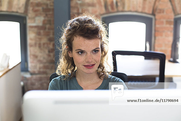Junge Frau am Schreibtisch im modernen Büro