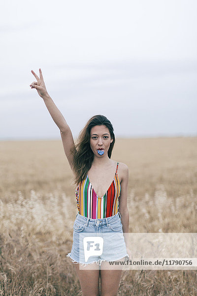 Woman with discolored tongue standing in field