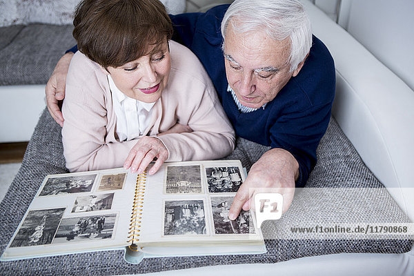 Seniorenpaar auf der Couch liegend  Blick auf Fotoalbum