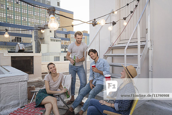 Friends having a rooftop party on a beautiful summer evening