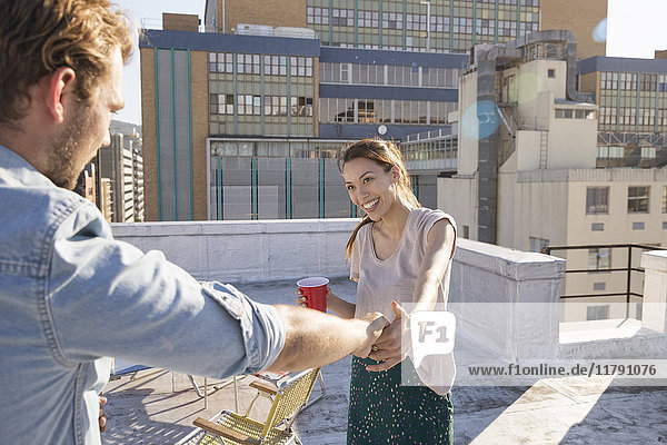 Young couple celebrating on a rooftop terrace  dancing together