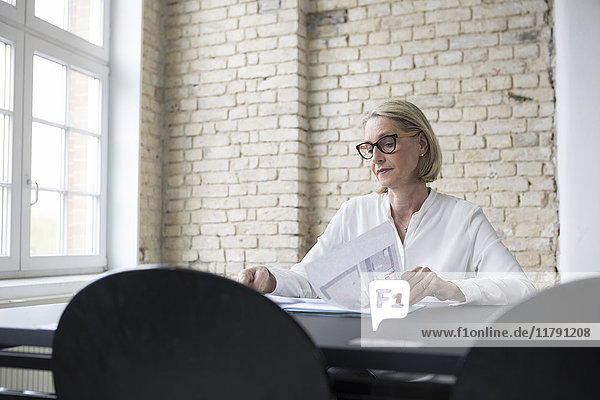 Mature businesswoman working in office  reading documents